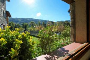 a view of a garden from a window of a house at El Jardí Casa rural ideal para familias y grupos in Arfa