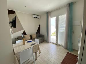 a living room with a table and a couch at Lux apartments in Porto Cesareo