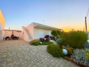 a garden with a house and a patio at Lux apartments in Porto Cesareo