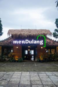 een bord voor een restaurant met een rieten dak bij Mendulang Lembang Resort & Resto in Bandung