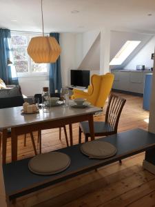 uma sala de estar com uma mesa e cadeiras amarelas em Rosinas - Fräulein Thäsler em Oberstaufen