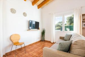 ein Wohnzimmer mit einem Sofa und einem Stuhl in der Unterkunft Villa Ses 5 Claus in Cala en Blanes