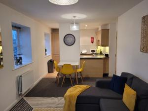 a living room with a couch and a kitchen at Catchpole Stays Abbey Field Apartment- A lovely 2 bed apartment with field views near Colchester town centre in Colchester