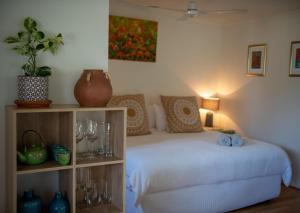 a bedroom with a bed and a shelf with wine glasses at Bower On Becket - Couples Retreat in Rye