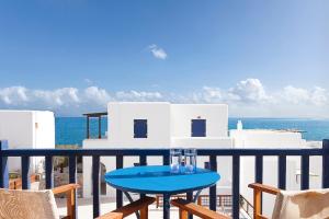 a blue table on a balcony overlooking the ocean at San Antonio Summer House by GHH in Piso Livadi