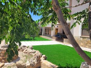 a yard with green grass and a house at Casas Rurales Noguericas in Archivel
