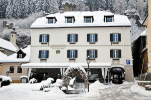 um hotel com neve no chão em frente a um edifício em Villa Bucher - Metnitztalerhof em Friesach