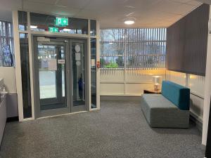 an empty lobby with a blue couch in a building at Premier Lodge in Falkirk
