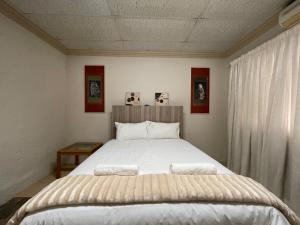 um quarto com uma cama grande e lençóis brancos em Nite Owl B&B em Koster