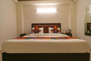 a bedroom with a large bed with colorful pillows at FabExpress Dolphin International in New Delhi