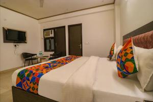 a bedroom with a large bed with a colorful blanket at FabExpress Dolphin International in New Delhi