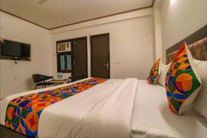 a bedroom with a large bed with a colorful blanket at FabExpress Dolphin International - Nr IGI Airport New Delhi in New Delhi +21 photos