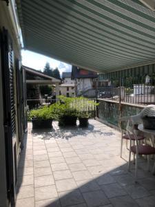eine Terrasse mit einem Tisch, Stühlen und einer Markise in der Unterkunft La Pineta Santa Maria Maggiore Locazione Turistica in Santa Maria Maggiore