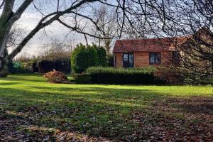 a house in a yard with a green lawn at Chalet Duras in Sint-Truiden +2 photos