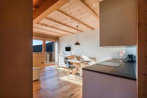 a kitchen and living room with a table and a desk at Brugghof Apartement Lärche in San Felice