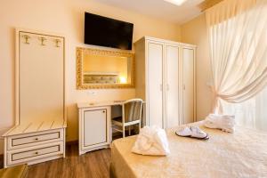 a bedroom with a bed and a desk and a mirror at Hotel Mazzanti in Milano Marittima