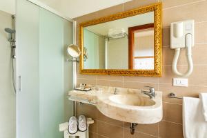 a bathroom with a sink and a mirror at Hotel Mazzanti in Milano Marittima