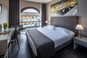 a hotel room with a bed and a large window at Hotel Palazzo Delle Stelline in Milan