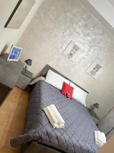 a bedroom with a gray bed with red and white pillows at La casa di Angy in Terrasini