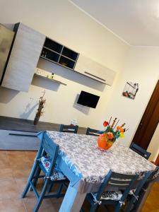 a dining room table with blue chairs and a kitchen at La casa di Angy in Terrasini