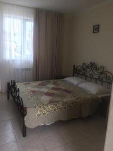 um quarto com uma cama com uma colcha em Villa Lubomir em Vityazevo