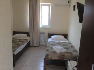 Duas camas num pequeno quarto com uma janela em Villa Lubomir em Vityazevo