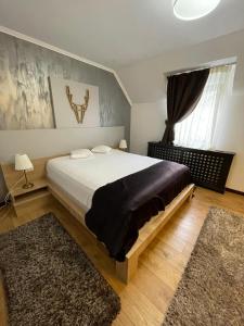 Un dormitorio con una cama grande y una ventana en PENSIUNE RESTAURANT CAPRA NEAGRA, en Moisei