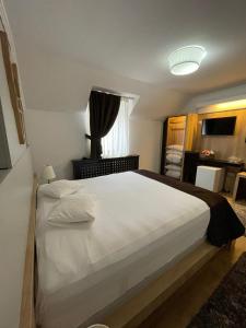 um quarto com uma grande cama branca num quarto em PENSIUNE RESTAURANT CAPRA NEAGRA em Moisei