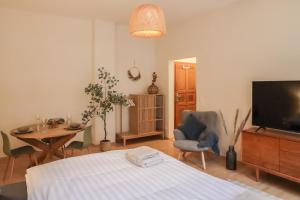 Schlafzimmer mit einem Bett, einem Tisch und einem TV in der Unterkunft Sleepwell Apartment - Emilienblick in Leipzig