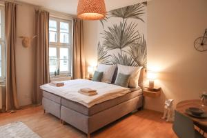 una camera da letto con un letto con una pianta sul muro di Sleepwell Apartment - Emilienblick a Lipsia