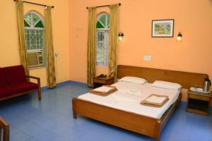 a bedroom with a bed and a chair and two windows at Mayem Lake View in Maem