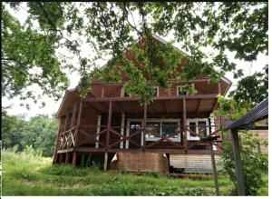 a large wooden house sitting on top of a lush green field at Ладога Новая in Vladimir