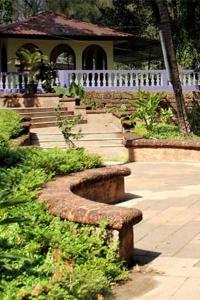 a stone bench in front of a house at Mayem Lake View in Maem