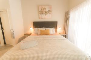 a bedroom with a large bed with a checkered blanket at MARGARET FOREST RETREAT Apartment 129 - Located within Margaret Forest, in the heart of the town centre of Margaret River, spa apartment! in Margaret River Town
