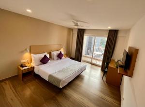 a hotel room with a bed and a balcony at Hotel The Golden Sands, Located on Calangute Main Road in Calangute +19 photos