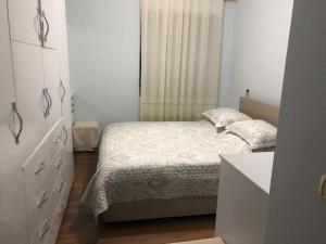1 dormitorio con 1 cama, vestidor y ventana en Kris's apartment, en Lezhë