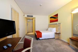 a hotel room with a bed and a flat screen tv at Bes Hotel Bergamo Ovest in Mozzo