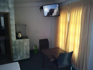 a room with a table and a television on the wall at Jily Stay in Kandy