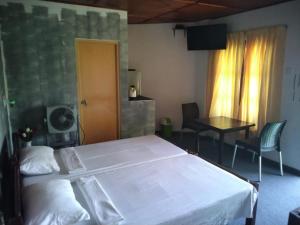 - une chambre avec un grand lit blanc et une table dans l'établissement Jily Stay, à Kandy