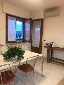 d'une cuisine avec une table, des chaises et des fenêtres. dans l'établissement MGM HOME AREZZO, à Arezzo