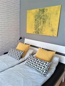 sypialnia z 2 łóżkami z poduszkami i obrazem w obiekcie Apartament blisko morza - Yellow Stone w Gdańsku