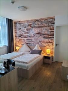 a bedroom with a bed and a stone wall at Wachtendonker Hof in Wachtendonk