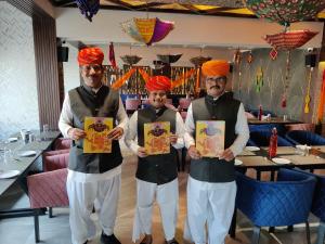 Tres hombres con turbante llevando certificados en un restaurante en Chandra Inn, en Jodhpur