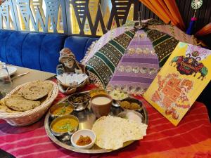 uma mesa com uma bandeja de comida e um guarda-chuva em Chandra Inn em Jodhpur