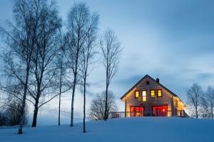 uma casa sentada em cima de um campo coberto de neve em Vasekoja Holiday Center em Vahtseliina