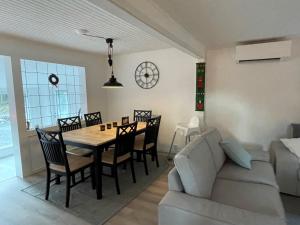 a dining room with a table and chairs and a couch at Asserbostugan in Överlida