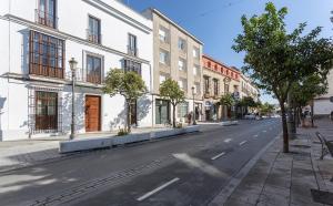an empty street in a city with buildings at LaLa Suites Corredera Centro in Jerez de la Frontera