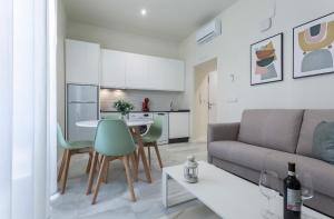 ein Wohnzimmer mit einem Sofa und einem Tisch in der Unterkunft LaLa Suites Corredera Centro in Jerez de la Frontera