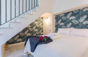 een slaapkamer met een wit bed met bloemen erop bij LaLa Suites Corredera Centro in Jerez de la Frontera