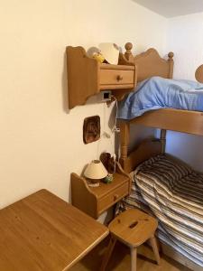 a bedroom with a bunk bed with a table and a desk at Appartamento con giardino privato in La Salle